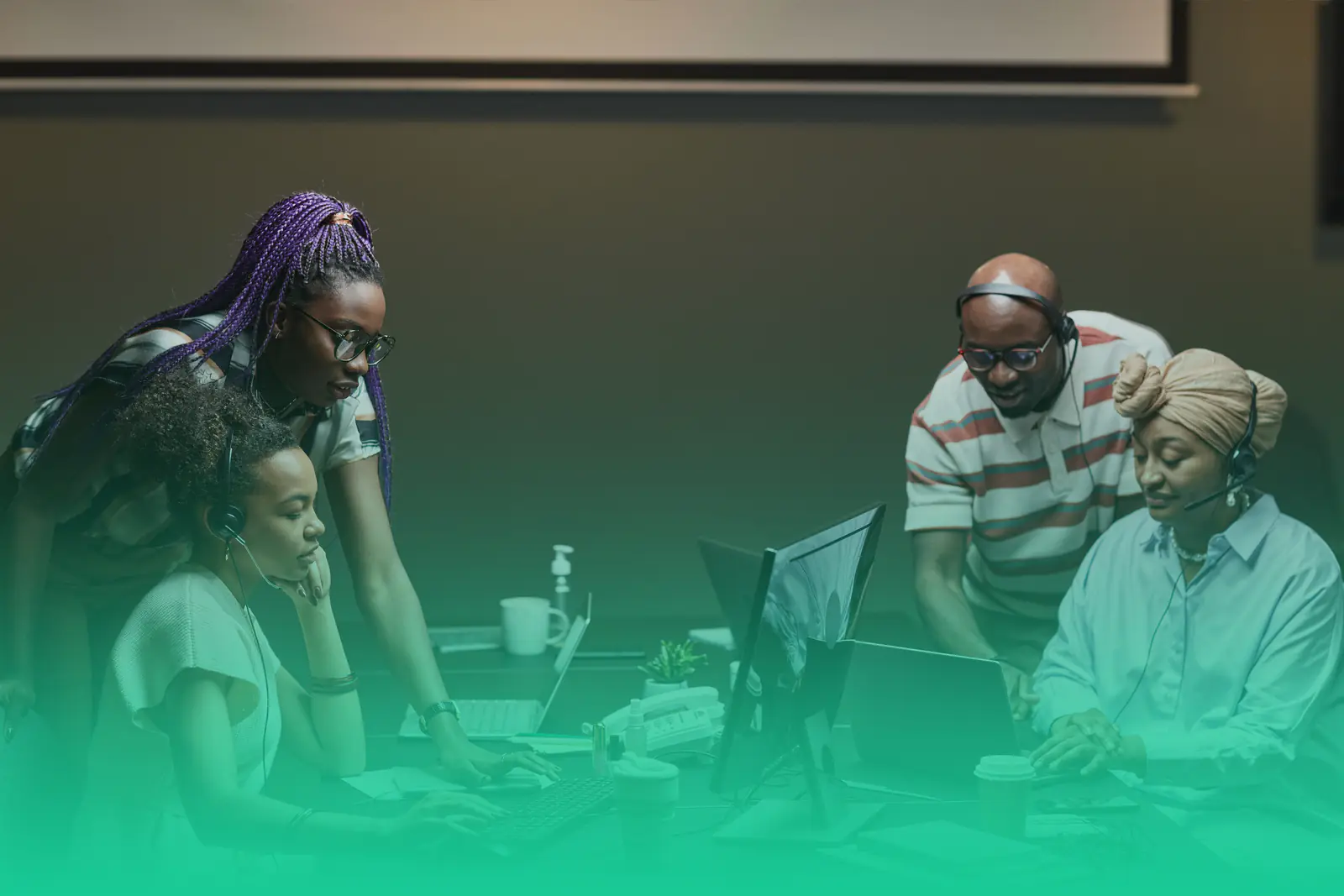 Four colleagues with headsets working together at their desks